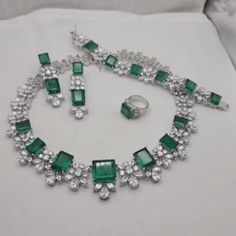 Doublet Necklace feature beautiful big green gemstone and cubic zirconia. Perfect for weddings, this statement piece is designed to dazzle. An ideal bride gift, it also makes a thoughtful present for your sister, adding elegance and charm to any special occasion. *𝐏𝐑𝐎𝐃𝐔𝐂𝐓 𝐃𝐄𝐓𝐀𝐈𝐋* * 𝐌𝐚𝐭𝐞𝐫𝐢𝐚𝐥: Brass * 𝐏𝐥𝐚𝐭𝐢𝐧𝐠: White Rhodium Plated * 𝐒𝐭𝐨𝐧𝐞: AAA-quality CZ Diamond & Doublet. 𝐕𝐢𝐬𝐢𝐭 𝐎𝐮𝐫 𝐅𝐀𝐐𝐬 𝐟𝐨𝐫 𝐒𝐡𝐢𝐩𝐩𝐢𝐧𝐠 𝐏𝐨𝐥𝐢𝐜𝐢𝐞𝐬 𝐚𝐧𝐝 𝐂𝐚𝐫𝐞 𝐈𝐧𝐬𝐭? Luxury Traditional American Diamond Necklace, Formal Bridal Necklace With Emerald Gemstones, Luxury Emerald Cut Wedding Necklaces, Luxury Emerald-cut Wedding Necklaces, Luxury Bridal Necklace With Gemstones, Luxury Diamond Bridal Necklace With Stones, Formal Emerald Cut Cubic Zirconia Necklace, Luxury Wedding Jewelry Sets With Gemstones, Luxury Bridal Necklace With Gemstones For Wedding