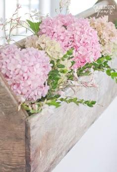 some pink and white flowers in a wooden box