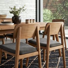 a dining room table with chairs and a potted plant