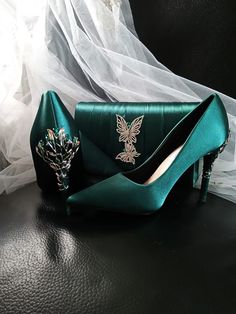 Elevate your evening ensemble with these exquisite Forest Green Satin Evening Shoes. Perfect for a Gothic Wedding, these stunning heels are a must-have for any bride or bridesmaid looking to make a statement. The carved detailing adds a touch of elegance, while the matching clutch bag ensures a coordinated and polished look for any formal event. Step out in style and grace with these luxurious heels and clutch set that are sure to turn heads and make you stand out from the crowd. Specifications: Green And Gold Heels, Luxurious Heels, Dark Green And Silver, Emerald Green Heels, Wedding Heels For Bride, Forest Green And Gold, Heels For Bride, Heels For Wedding, Shoes Gothic