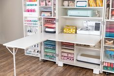 a sewing room with lots of craft supplies on the shelves and desks in front of it