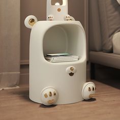 a white bear shaped night stand on the floor