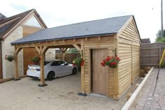 a car is parked in front of a wooden garage with flowers on the door and windows