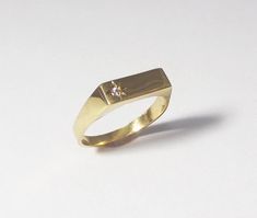 A 14k solid gold signet engagement ring with a diamond. This lovely minimal and clean designed signet ring is made of solid 14k gold and has a small diamond on one side (1.5 ct). The shiny diamond is set in a star designed inlay, which gives this ring yet more character and sparkle. This ring can be a great modern engagement ring or a high-class gift for any other happy occasion such as birthdays, births, anniversaries and more. This rin is great for everyday use - it is light and comfortable to White Gold 14k Signet Ring With Single Cut Diamonds, Modern Diamond Signet Ring As Gift, Modern Signet Ring With Single Diamond In Open Style, Modern Open Signet Ring With Single Diamond, Minimalist Formal Signet Ring With Single Diamond, Minimalist Signet Ring With Single Cut Diamonds, Minimalist Diamond Signet Ring With Polished Finish, Modern Diamond Signet Ring For Promise, Modern Formal Signet Ring With Single Diamond