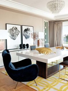 an elegant dining room with modern chairs and artwork