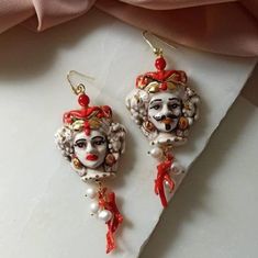 Baroque style earrings made of: - Sicilian handpainted Ceramic heads; - Red Natural Coral branches; - Gold plated 925 Sterling Silver hooks. Lenght : 7,5 cm / 2,96 inches * SHIPPING * Your order will be shipped within 1-3 business days from your purchase. You can choose between 2 shipping methods: STANDARD MAIL (NOT TRACEABLE) It is a cheap and fast shipping method, but NOT TRACEABLE. Chapeau Atelier is not responsible for any postal disruptions, delays or losses. REGISTERED MAIL (TRACEABLE) It Ornate Red Dangle Earrings, Ornate Red Earrings For Party, Red Hand Painted Earrings For Gift, Artistic Red Earrings For Gifts, Red Hand Painted Drop Earrings, Red Artistic Drop Earrings, Baroque Pierced Earrings As Gift, Red Hand-painted Dangle Jewelry, Red Hand Painted Dangle Jewelry