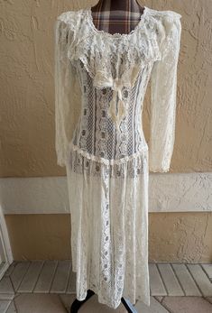 Beautiful, possibly never worn lace dress with vertical lace theme,does not have a slip as this is not lined and will require one.  Oversized Lace dimensional  collar which wraps around on the back. Lace long sleeve, scalloped style edging trims collar, edging on sleeves, and neckline. Rear plastic zipper which denotes time frame to be post 70's vs. the Victorian or Edwardian era which the dress appears to represent in a retro way. Measurements taken flat, so please remember to double: armpit-ar Long Lace Dress For Daywear, Long Lace Dress With Lace Work, Vintage Lace Maxi Dress For Daywear, Lace Trim Long Maxi Dress, White Lace Maxi Dress For Daywear, Vintage Lace Patchwork Beach Dress, Fitted Maxi Dress With Lace Patchwork For Daywear, Fitted Lace Patchwork Maxi Dress For Daywear, Fitted Long Lace Dresses