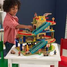 The KidKraft Wash n Go Wooden Car Garage was a Toy of the Year Awards finalist in 2017. Packed with interactive fun, this playset will keep kids engaged and having imaginative fun for hours. Kids can take the included wooden cars up the elevator to the top floor where a helicopter waits on its pad. Zoom down the ramps past the mechanic’s shop and smiling townsfolk to the car wash with its spinning brushes. Fuel up at the gas station, then it’s back to the elevator to do it all again. This playse Wooden Car Garage, Toy Race Track, Shed Playhouse, Play Teepee, Infant Development, Wooden Playset, Pirates Cove, Wash N Go, Magical Home