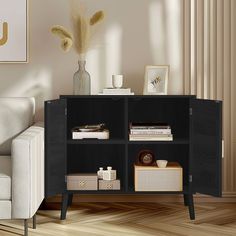 a living room with a white couch and a black cabinet in the corner that has books on it