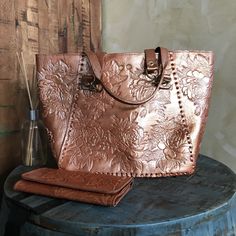 MADE IN MEXICO By: Mexican Artisans Details: Bag Style: Tote Bag Color: Copper Gold 100% Authentic Leather Hand-tooled Floral Design 16" x 11" x 4.5" Handle Straps: 11.5" Drop Closure: Twist Lock Interior: Suede Fabric Flat Bottom Long Leather Wallet: Color: Copper Gold Hand Tooled Floral Design 8" x 4" Closure: Magnetic Snap 1 Zipped Coin Compartment 2 Money Compartments 10 Card Compartments Contact us for more details PLEASE READ BEFORE PURCHASE: Each product is handmade from Mexico causing di Vintage Embossed Satchel For Everyday Use, Embossed Satchel Shoulder Bag For Everyday Use, Everyday Embossed Tote Satchel, Embossed Double Handle Bag For Daily Use, Embossed Bags With Double Handle For Daily Use, Daily Use Embossed Bags With Double Handle, Brown Embossed Tote Shoulder Bag, Double Handle Embossed Shoulder Bag For Daily Use, Vintage Embossed Tote Bag