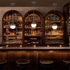 the bar is lined with bottles and stools