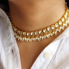 R O S H   J E W E L R Y Welcome to Rosh! Launching this pearl choker for all the moti lovers.   This celebrity-inspired choker is subtle and vibrant at the same time! You can pair it up with a long necklace for a heavier look or wear it as is! This choker is so adorable and can be worn with a kurta or Anarkali alone too for that ethnic day look! If you're a bride-to-be looking to add some very artistic and unique jewelry to your bridal couture, then we have got you covered, and how?! This neckla Bollywood Style Temple Choker Necklace For Festive Occasions, Bollywood Tilla Choker For Navratri, Bollywood Style Festive Temple Choker Necklace, Bollywood Style Tilla Choker For Navratri, Festive Bollywood Temple Choker Necklace, Bollywood Style Gold Kundan Necklace, White Kundan Necklace With Mirror Work For Party, Bollywood Choker For Navratri Festival, Bollywood Style Temple Necklace With Gota Work