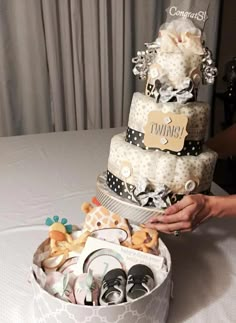 a cake that is sitting on top of a table with baby shoes in the middle