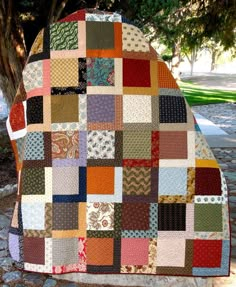 a patchwork blanket sitting on top of a tree