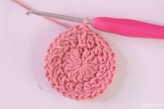 the crochet pattern is being worked on with a pair of pink scissors and yarn