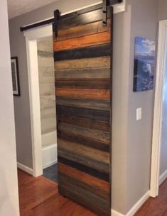 a sliding door made out of wooden planks in a room with hard wood flooring