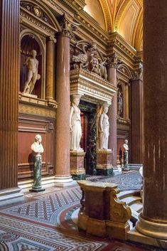 the inside of a building with statues and columns