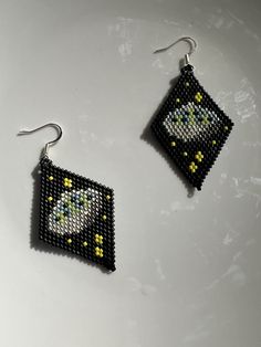 a pair of beaded earrings on a white surface