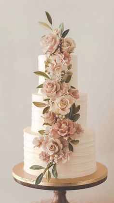 a white wedding cake with flowers on top