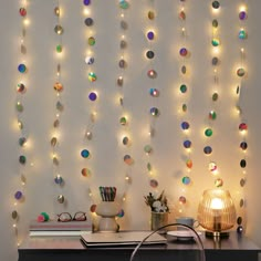 a desk with some lights on it and a lamp in front of the wall behind it