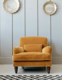 a yellow chair sitting in front of two mirrors