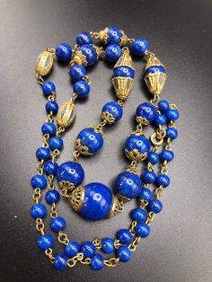 "Neiger Brothers Lapis blue glass beaded necklace with enamelled bead caps and metal beads.  Lovely array of pretty bead caps, a long length in great condition. The beads have gold flecks in them and the bolt ring clasp has Czechoslov impressed in it. Length: end to end 28\" Centre bead with bead caps = 3/4\"" Vintage Necklace With Bead Caps And Round Beads, Vintage Necklaces With Round Beads And Bead Caps, Vintage Necklaces With Bead Caps And Round Beads, Vintage Beaded Necklace With Bead Caps, Antique Beaded Chain Necklace, Vintage Long Necklace With Large Round Beads, Vintage Blue Beaded Necklaces With Spacer Beads, Blue Beads With Bead Caps For Jewelry Making, Vintage Blue Polished Beads Jewelry