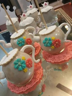 teapots with flowers on them are sitting on display