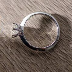 a diamond ring sitting on top of a wooden table