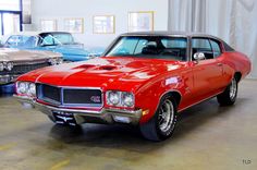 an old red car is parked in a garage