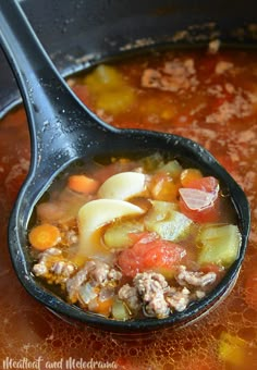 a spoon full of soup with meat and vegetables