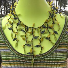 Vines and Leaves Enchanted Autumn Forest Statement Necklace Handcrafted in Eco-friendly Glass beads. The Perfect  Fall Wedding Jewelry or Bridesmaid Gift. *The beaded base is black and the tiny leaves are a chartreuse green, metallic grey and citrus yellow, all accented with larger seed beads. *The Necklace is 18 inches around and can be adjusted to 20 inches around using one of the three balls for closure. *Each Necklace comes Elegantly Gift Boxed with Enclosure Cards. Elegant Glass Necklace For Festivals, Elegant Festival Glass Necklace, Elegant Bead Cap Necklaces For Festivals, Elegant Festival Necklace With Bead Caps, Elegant Necklace With Bead Caps For Festivals, Elegant Yellow Beaded Necklaces With Tiny Beads, Handmade Yellow Necklaces For Wedding, Elegant Yellow Jewelry With Tiny Beads, Handmade Green Bridal Necklace For Party