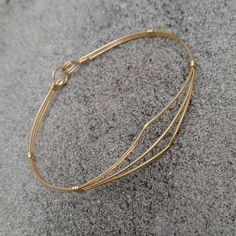 A delicate bracelet of three strands of lightweight 14kt gold filled wire pulled open in a dainty pointed design. So sweet and feminine, it would make an ideal gift for a young lady's confirmation, graduation, or birthday! The sturdy built-in hook and eye clasp is easy to get on and off by yourself. Choose the best size from the variations for a perfect fit! Add on a jewelry polishing cloth to keep your bracelet--and ALL your jewelry--shiny clean! https://www.etsy.com/listing/732310828/jewelry-p Adjustable Delicate 14k Gold-filled Bracelets, Delicate Adjustable Bangle Bracelet, Adjustable Gold Minimalist Wrap Bracelet, Delicate Adjustable Gold Bangle Bracelet, Gold Wire Wrapped Bracelets In 14k Gold Filled, Gold Wire Wrapped 14k Gold-filled Bracelets, Wire Wrapped 14k Gold Filled Bracelets, Adjustable Yellow Gold Nickel-free Bracelet, Adjustable Dainty 14k Gold Bangle