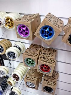 several different types of skate wheels on display in a store with cardboard boxes hanging from the ceiling