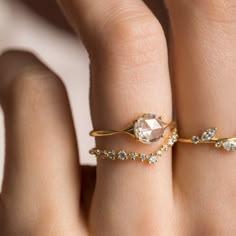 a woman's hand with two rings on it and one is wearing a diamond ring