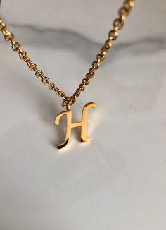 Letter H necklace, set on a stainless steel ,golden color chain. Chain length 19'  With addition cost there is an option to add a white freshwater pearl, as a charm, next to the letter. 6 mm, white round pearl Kindly choose your option. Beautiful spiritual gift. Please make sure you to pay attention to the size of the pendant. I have added pictures next to 25 cent coin, and measurement tape.  Need a different length just write it to me in the "message to the seller" box of the order form. **LIMI H Letter Necklace, H Necklace Initial, Gold Minimalist Initial Necklace In Stainless Steel, Minimalist Gold Stainless Steel Initial Necklace, Gold Dainty Stainless Steel Name Necklace, Dainty Gold Stainless Steel Name Necklace, Hypoallergenic Gold Initial Necklace Gift, Letter H Necklace, H Name