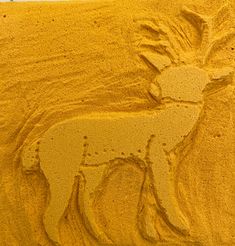 an animal drawn in sand on the beach