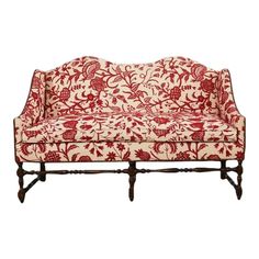 a red and white couch sitting on top of a wooden frame