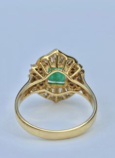 "Pacific Jewelry Presents, Art Deco inspired natural Colombian Emerald ring mounted in 18k solid gold. Center stone Emerald has a vibrant deep green color hue with brilliant white diamond adornments. Emerald ring is part of 3 piece Emerald set featuring a matching necklace and stud earrings. Certificate of appraisal can be included upon request. <> ✔ Natural, genuine Emerald ✔ Natural Diamonds ✔ Gold Karat: 18K ✔ Center Emerald Shape: Emerald Cut ✔ Center Emerald Weight: 1.62 carats ✔ Emer Luxury Green Emerald Hallmarked Ring, Luxury Green Oval Cluster Ring, Exquisite Green Diamond Ring With Brilliant Cut, Luxury Green Diamond Halo Ring, Gia Certified Green Emerald Art Deco Ring, Luxury Green Cluster Ring With Center Stone, Luxury Green Diamond Ring Hallmarked, Exquisite Green Emerald Ring With Halo Setting, Art Deco Green Ring, Gia Certified