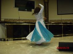 a woman in a blue and white dress dancing on the dancefloored floor