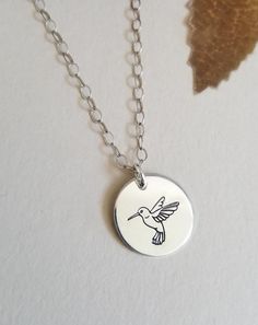 The Bird of Joy, the Hummingbird is a symbol of courage and determination. Wear this necklace as a reminder of your own courage within. A solid disc charm is hand engraved with the beautiful and profoundly meaningful Hummingbird. The circle charm measures 15 mm and floats on shimmering Sterling Silver, Gold Filled or Rose Gold Filled chain in your choice of length. Necklaces are all crafted with genuine materials not plated, so they will never peel, chip or flake off. Handcrafted with love, our Symbol Of Courage, Hummingbird Necklace, Necklace Everyday, Bird Charm, Bird Necklace, Moonstone Bracelet, Everyday Necklace, Minimal Jewelry, Nature Inspired Jewelry