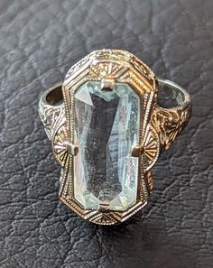 Antique 1920s era Art Deco Aquamarine ring. Aquamarine is emerald cut and weighs 4.8 carats. Stone is prong set in an ornate 14k White Gold filigree setting with miligrain work on edges. Aquamarine is March's birthstone. The ring is fully hallmarked and will arrive gift boxed. MARKS 14k. CONDITION In very good to excellent condition with light wear. Please use all pictures as part of item's description. SIZE 5 1/2, ring could be resized by any good jeweler. MATERIALS Aquamarine, 14k White Gold Art Deco Jewelry For Vintage Events, Vintage 14k Stamped Sapphire Ring For Formal Occasions, Art Deco Emerald Ring With 17 Jewels For Anniversary, Art Deco Emerald Jewelry With Rose Cut Diamonds, Art Deco Emerald Ring In Baguette Cut White Gold, Vintage Emerald Ring With Rose Cut Diamonds, Silver Art Deco Diamond Ring With Octagon Shape, Art Deco Rectangular Emerald Ring For Anniversary, Silver Octagon Art Deco Diamond Ring