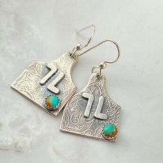 Discover the perfect accessory for the cowgirl bride with our Sterling Silver Initial Cow Tag Earrings, a unique blend of personalized elegance and rodeo charm. These custom letter earrings make an unforgettable gift, embodying the spirit of the rodeo with a chic, personalized touch. Personalize with your initial or brand placement will depend on brand or initials. You can add 2 initials to this for best fit and look. ◈ FEATURES ◈ ☙ Personalized cow tag earrings☙ Crafted from solid sterling silv Stamped Dangle Jewelry, Elegant Personalized Turquoise Jewelry, Southwestern Stamped Jewelry As Gift, Rustic Drop Earrings Jewelry Gift, Rustic Drop Earrings Jewelry For Gift, Rustic Drop Earrings As A Gift, Rustic Turquoise Earrings For Gift, Elegant Stamped Earrings As Gift, Rustic Sterling Silver Dangle Jewelry