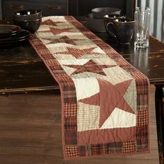 a table runner with a red and white plaid star design on it, sitting on a dining room table