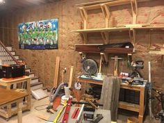 a room filled with lots of tools and wooden shelves next to a painting on the wall