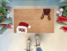 Handmade coir doormat with a Santa face and reindeer design. Made in the USA, available in three sizes, perfect for adding holiday cheer to your entryway. Christmas Coir Doormat, Christmas Mat Painting Ideas, Diy Painted Doormat Christmas, Diy Christmas Floor Mat, Diy Christmas Rug, Painted Door Mat Christmas, Coir Doormat Diy Christmas, Christmas Outdoor Rug, Western Door Mats