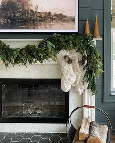 the fireplace is decorated with greenery and stockings hanging from it's mantel