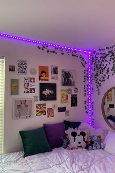 a bedroom with purple lights and pictures on the wall