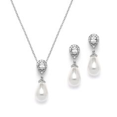 a necklace, earrings and ring set with white pearls on a chain in silver tone