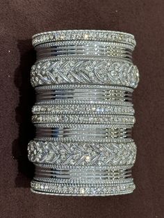 NAZRANAA JEWELS OFFERS A GREAT RANGE OF INDIAN JEWELRY FOR TODAY'S WOMAN WITH THE LATEST DESIGNS. THE BRAND IS COMMITTED TO PROVIDING ITS CUSTOMERS WITH THE HIGHEST QUALITY OF GOODS AND NEWEST DESIGNS. IT IS SUITED FOR A WOMAN WHO IS LOOKING TO STAY DATED WITH THE LATEST TRENDS. RADIANT SILVER BANGLES IS A PERFECT ACCESSORY FOR ANY NIGHT EVENT. IT IS SURE TO MAKE YOU STAND OUT IN A CROWDED ROOM.  Traditional Indian Jewelry: Slight Color variations possible due to difference in screen and photograph.If you are interested in purchasing this item and have any questions about this item, please feel free to send us a message. Care instructions Keep Jewelry away from direct heat, water, perfumes, deodorants and other strong chemicals as they may react with the metal or plating.  Perspiration (sw Silver Bridal Sets With Rhinestones For Wedding, Adjustable Silver Bridal Sets For Party, Silver Bridal Sets With Rhinestones For Party, Silver Bangle With Rhinestones As Gift, Silver Rhinestone Bangle, Silver Stackable Crystal Bracelet For Wedding, Stackable Silver Crystal Bracelet For Wedding, Adjustable Silver Crystal Bangle, Adjustable Silver Sparkling Bangle