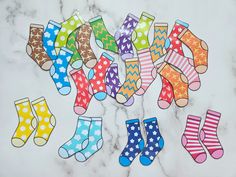 several pairs of colorful socks sitting on top of a white marble counter with polka dots